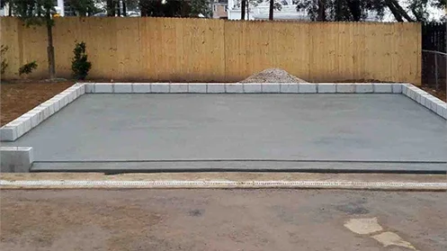 Square concrete foundation with a row of bricks